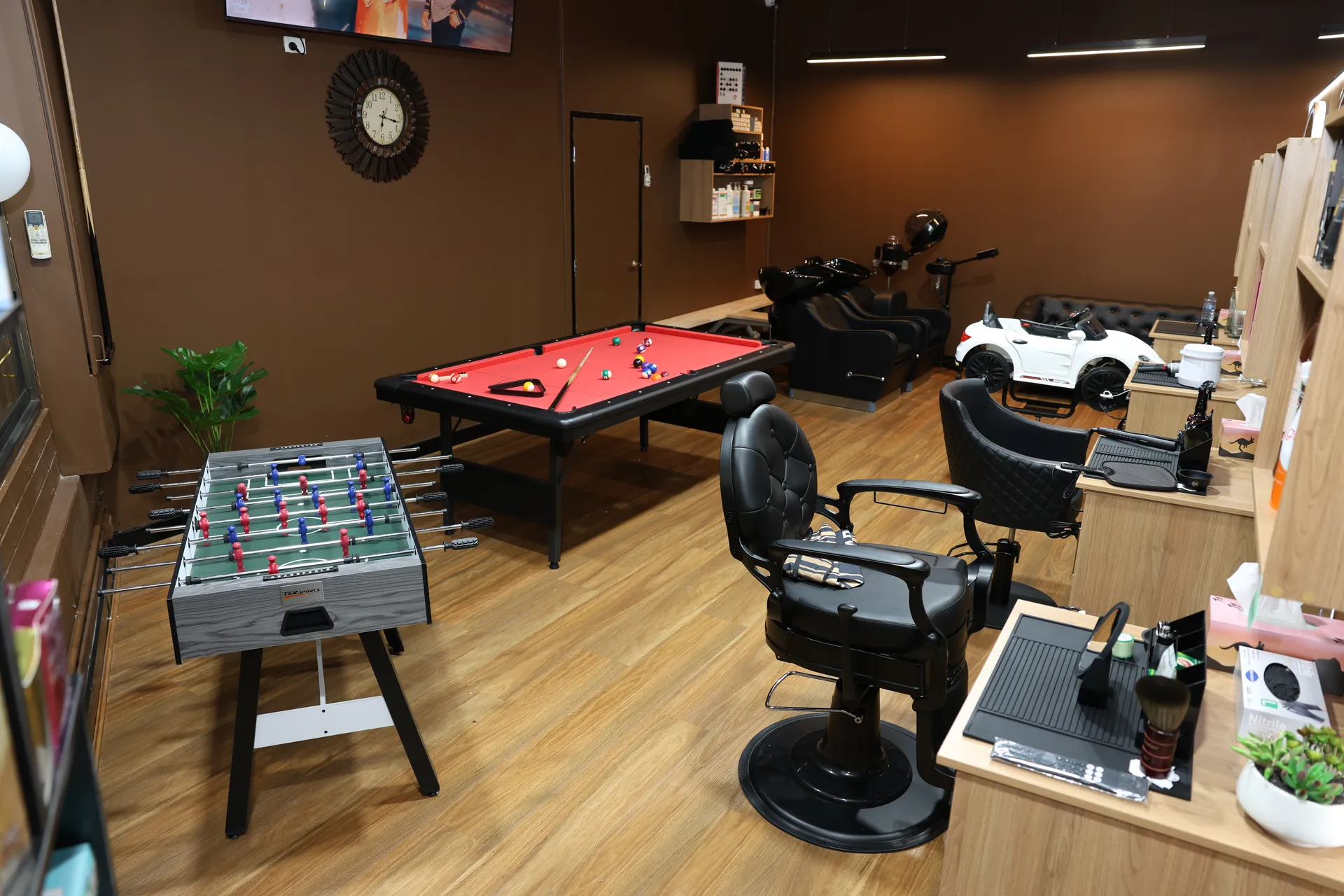 The recreation corner with pool table and foosball beside the barber chairs