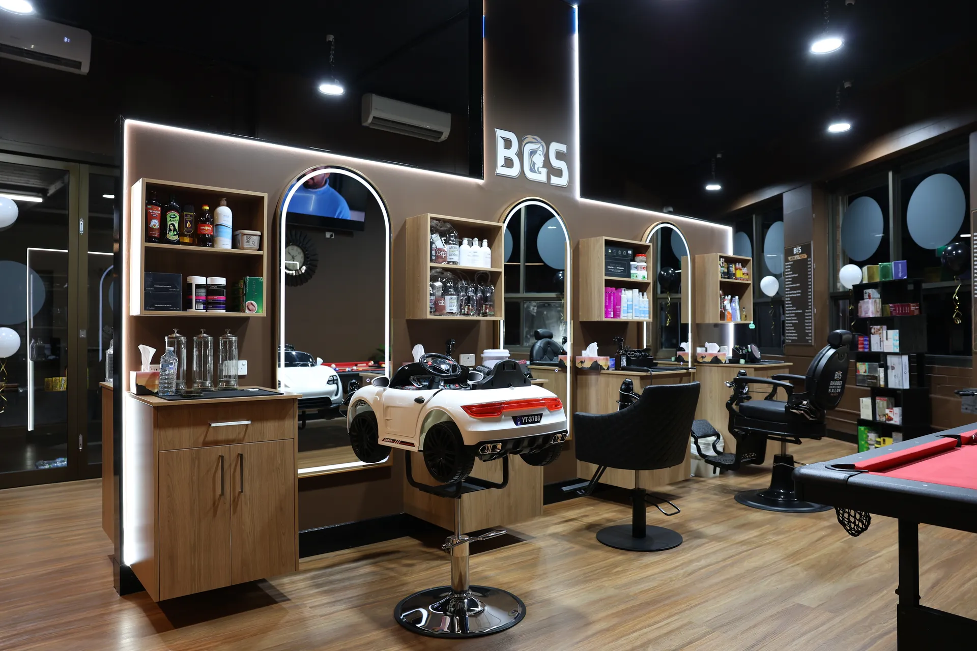 A wide view of the salon interior with styling chairs and the recreation corner