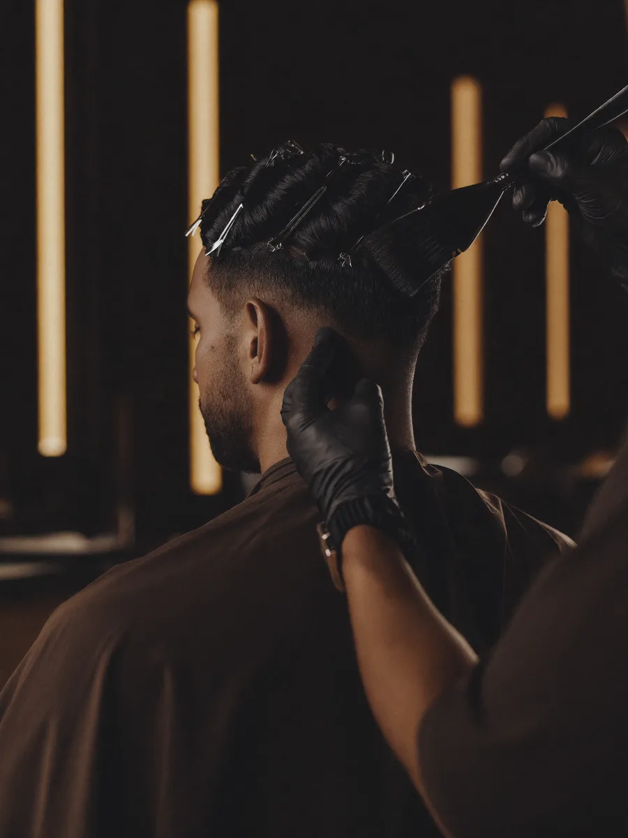 An Indian man having rich hair colour applied with a tint brush