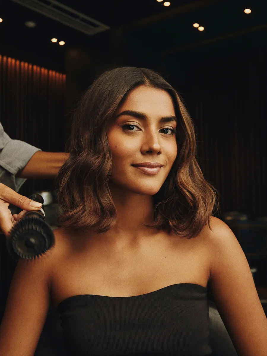 An Indian woman with a freshly styled shoulder-length blow-dry